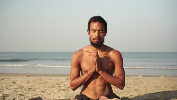 Чоловік займається йогою і медитацією в положенні лотоса в природі — стокове відео