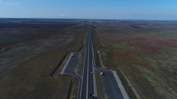 Panorama aéreo: estrada rural ou estrada contra o fundo do campo e do céu — Vídeo de Stock