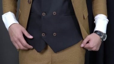 Klasik takım elbiseli adam boyunu aşmış. Soyunma odasındaki adam takım elbise giyiyor.