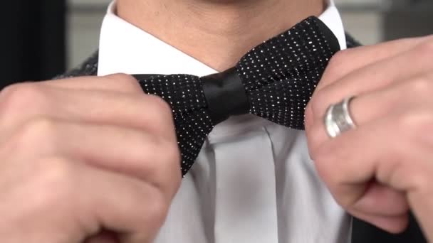 Un domn de sex masculin într-un costum clasic își îndreaptă cravata de arc — Videoclip de stoc