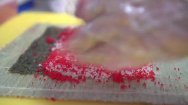 Adam mutfakta suşi hazırlıyor.