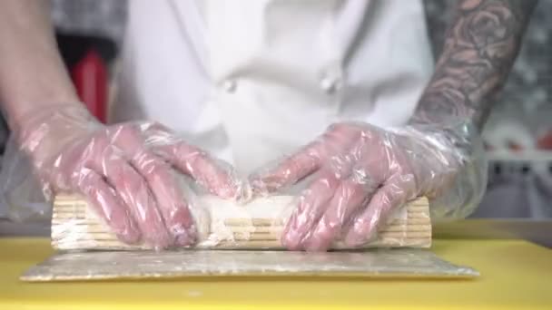 A male chef prepares Japanese sushi in the kitchen — Stockvideo