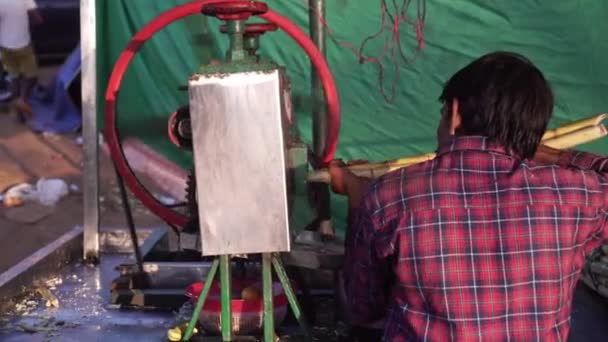 Mandrem, Indien, Februar 2020. Eine Person presst mit einem speziellen Mechanismus Saft aus Zuckerrohr. — Stockvideo