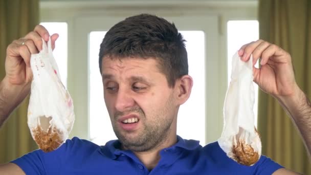 Un bărbat trist nefericit, un tată tânăr care ţine două scutece murdare pentru copii — Videoclip de stoc