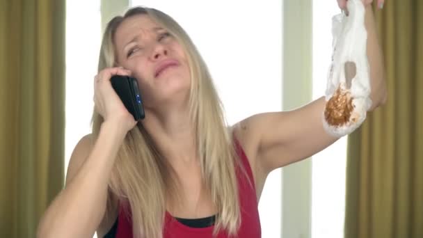 Mujer infeliz mamá está sosteniendo un pañal de bebé sucio y hablando por teléfono — Vídeos de Stock