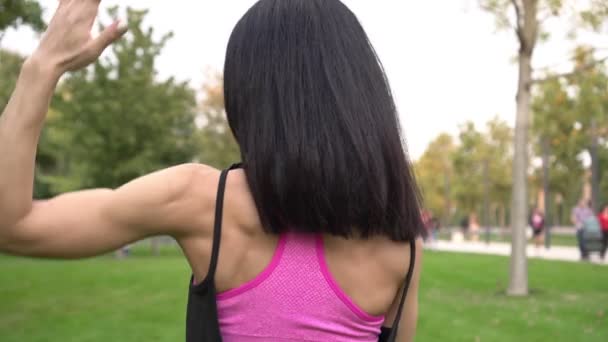アクティブなブルネットの女性は屋外の夏の公園でスポーツとフィットネスのために行く — ストック動画