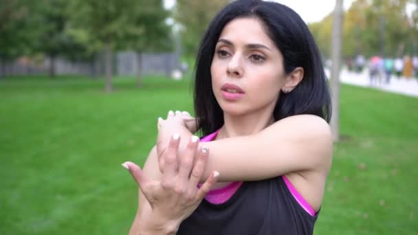 Sportowa atrakcyjna kobieta robi rozgrzewkę przed treningiem w parku — Wideo stockowe