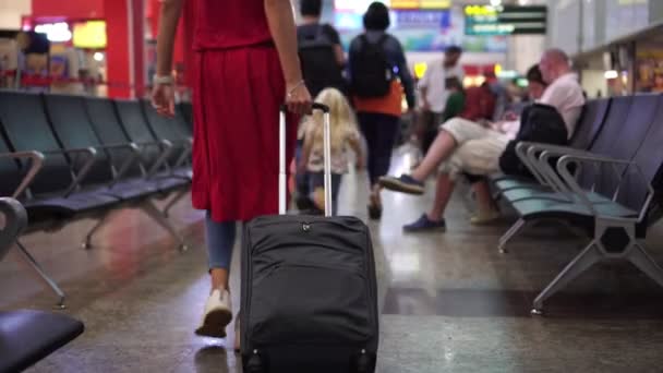 Делі, Індія - березень 2020 року. Жінка подорожує з дитиною на задньому плані терміналу аеропорту. — стокове відео