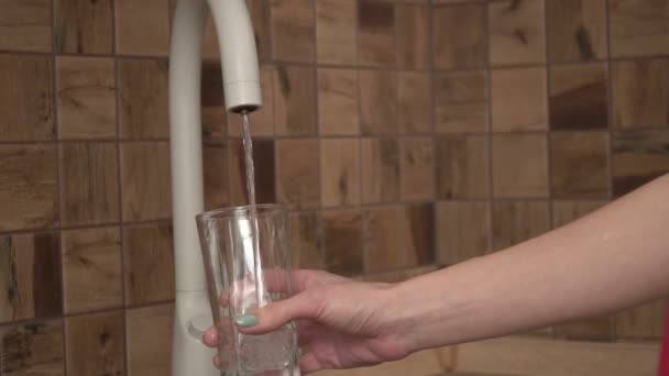Una persona vierte agua limpia y clara del grifo en un vaso, cámara lenta — Vídeos de Stock