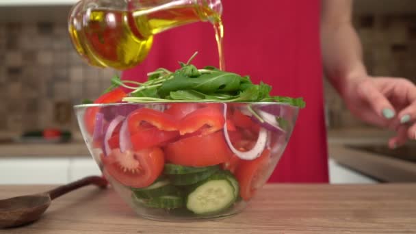 Una donna in cucina versa un'insalata di verdure con olio di oliva o di girasole — Video Stock