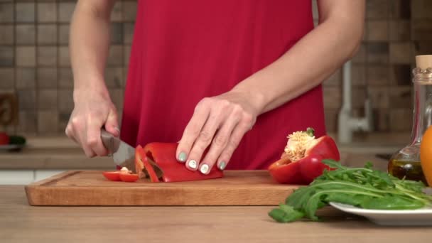 Mujer en la cocina corta pimentón rojo, cámara lenta — Vídeos de Stock