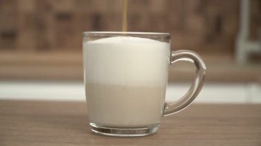Bir kupa cappuccino veya latte kahve. Sütlü kahve, cam bardakta yakın plan.