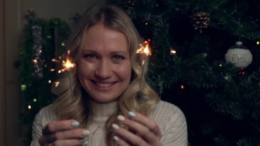 Bir kadın yanan maytaplar tutar ve Noel 'i ya da yeni yılı kutlar.