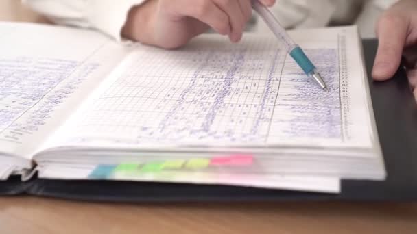 Schooldagboek of inschrijven met cijfers, close-up. De leraar leest het schooldagboek. — Stockvideo