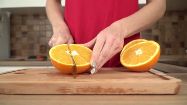 女性は台所でジューシーなオレンジを切っています,クローズアップ — ストック動画