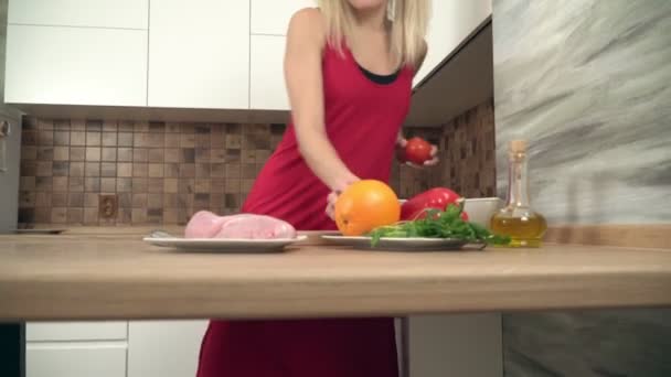 Joven mujer feliz está cocinando en la cocina. Retrato de una atractiva ama de casa positiva en la cocina — Vídeo de stock