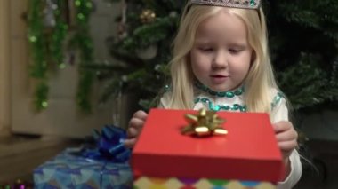 Çocuk Noel ya da Yeni Yıl için bir hediye kutusu açar