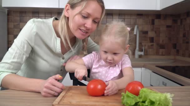 Mama i córka gotują w kuchni i robią sałatkę warzywną. Mama uczy córkę gotować. — Wideo stockowe