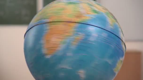 Okul küresi bir eksen üzerinde döner, yakın plan. Seyahat ya da eğitim kavramı — Stok video