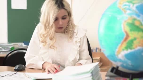 Woman school geography teacher checks the notebooks of the teachers. Teacher in the school class — Stock Video