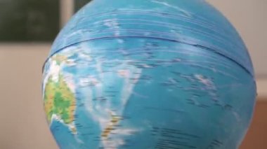 Okul küresi bir eksen üzerinde döner, ağır çekimde. Globe - okul eğitimi, coğrafya dersi veya seyahat kavramı