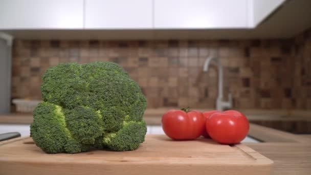 Verse groene broccoli en tomaten op de keukentafel, close-up — Stockvideo