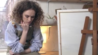 Üzgün kadın sanatçı ilham bekliyor. Yaratıcı bir krizde olan genç bir sanatçı