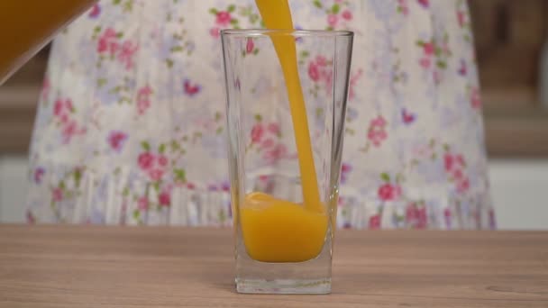 La mujer vierte jugo de fruta fresca de una jarra en un vaso, cámara lenta. Vaso de jugo recién exprimido, primer plano — Vídeos de Stock