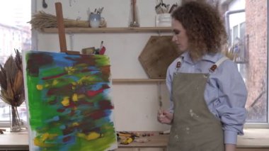 Modern duygusal kadın sanatçı yaratıcı bir krizde. Sanatçı sinirlenir ve fırçayı fırlatır.