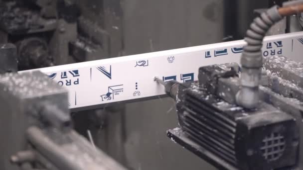 Una máquina automática de ingeniería hace un agujero en un perfil en una fábrica de ventanas de plástico. — Vídeo de stock