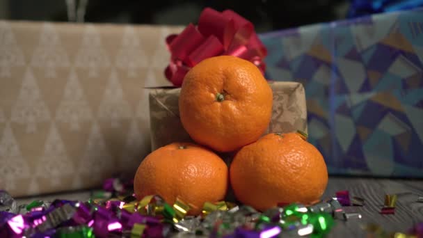 Pomarańczowe mandarynki na tle Nowego Roku lub pudełka świąteczne z prezentami. — Wideo stockowe