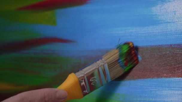 Un artiste peint un tableau avec un pinceau, gros plan d'un frottis de peinture sur la toile — Video