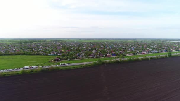 Vila ou cidade, estrada rural e terra arável, vista aérea. Paisagem rural, panorama aéreo — Vídeo de Stock