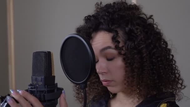 Kayıt stüdyosunda mikrofonun önünde şarkı söyleyen yorgun bir kadın. Bir sanatçının mesleğinde yaratıcı kriz — Stok video