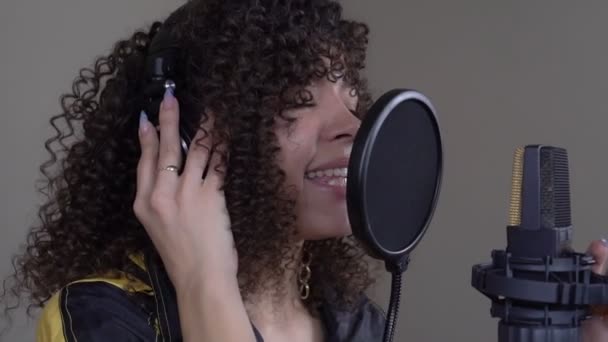 Молодая профессиональная чернокожая певица записывает песню в студии звукозаписи. Медленное движение — стоковое видео