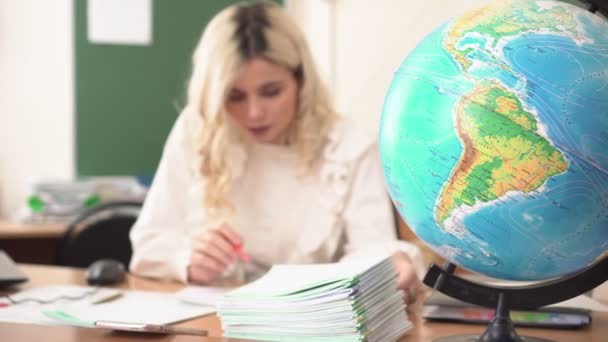 O professor de geografia verifica os cadernos dos alunos nas aulas. Professora da escola no trabalho — Vídeo de Stock
