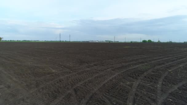 Arable land on the farm. Dug up black earth and a field for agriculture. Preparing the soil before planting plants — Stock Video