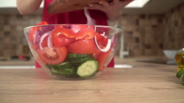 Bir kadın mutfakta cam bardakta sebze salatası yapıyor. — Stok video