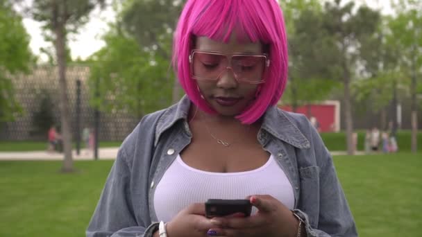Retrato de mujer negra atractiva moderna con teléfono inteligente al aire libre — Vídeos de Stock