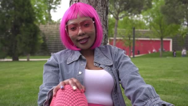Retrato de uma jovem mulher negra no cabelo rosa ao ar livre. Conceito de corpo positivo — Vídeo de Stock