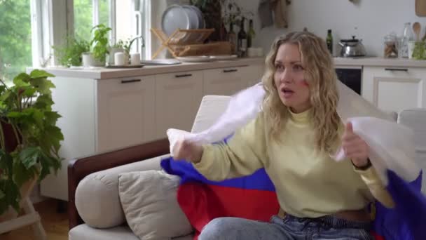 Desportos de mulher ou fã de futebol com a bandeira da Rússia. Uma mulher russa assiste TV em casa e apoia a equipe nacional russa — Vídeo de Stock