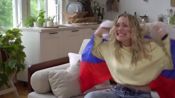 Çekici bir Rus kadının portresi, spor veya futbol fanatiği Rusya bayrağıyla evde. — Stok video