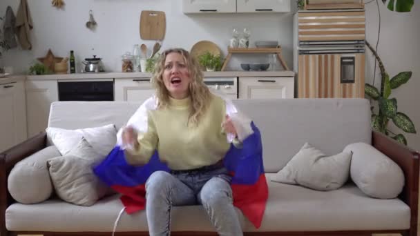 Приваблива російська жінка - спорт або футбольний фанат вдома з прапором Росії. — стокове відео