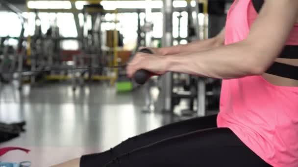 健美的女人在体育馆的模拟器上锻炼 — 图库视频影像
