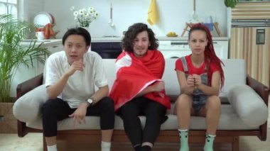 Bir grup Türk futbol taraftarı evde televizyon izliyor. Türkiye bayrağıyla spor taraftarları