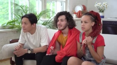 Türk futbol taraftarları evde televizyon izliyor. Türkiye bayrağıyla spor taraftarları