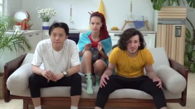 Arjantinli futbol taraftarları evde TV izler. Arjantin bayrağı taşıyan bir grup spor taraftarı