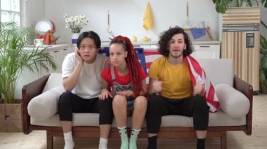 Amerika Birleşik Devletleri 'ndeki Amerikalı hayranlar evde TV izler. ABD bayrağı taşıyan duygusal sporseverler