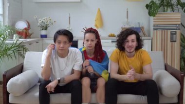 İsveçli futbol taraftarları evde TV izler. İsveç bayrağıyla duygusal sporseverler