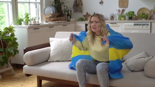 En kvinnlig sportfantast av det svenska landslaget tittar på TV hemma och stödjer laget — Stockvideo